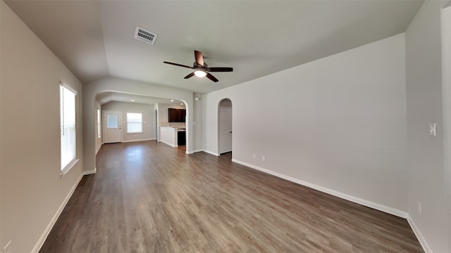 24734 Signorelli Way, Katy, TX 77493 - unfurnished living room with arched walkways, ceiling fan, dark wood finished floors, and baseboards