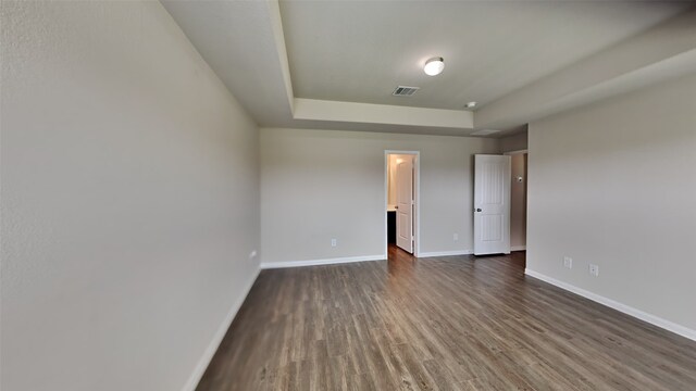 24734 Signorelli Way, Katy, TX 77493 - unfurnished bedroom featuring a raised ceiling, dark wood-type flooring, and baseboards