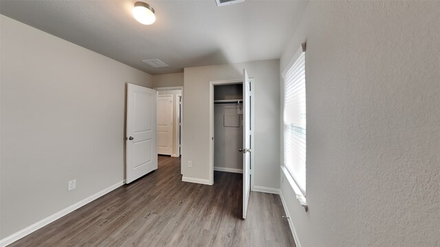 24734 Signorelli Way, Katy, TX 77493 - unfurnished bedroom with wood finished floors, baseboards, and a closet