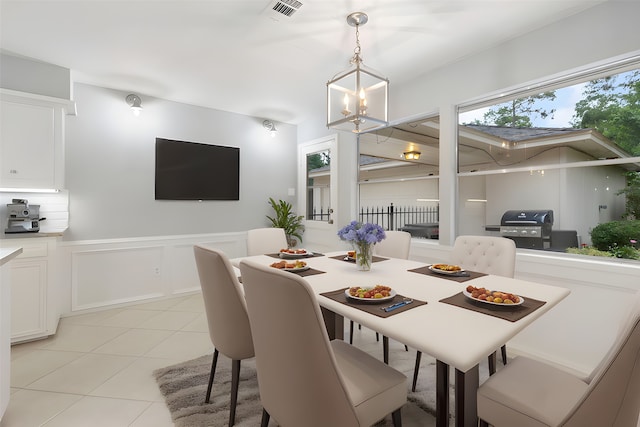 14010 Court Of Regents, Houston, TX 77069 - dining room with light tile patterned flooring, a chandelier, a decorative wall, and wainscoting