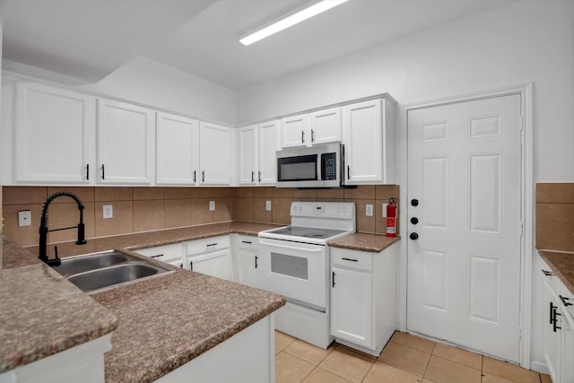 6933 Liverpool St, Houston, TX 77021 - kitchen featuring stainless steel microwave, white electric stove, a sink, backsplash, and white cabinetry