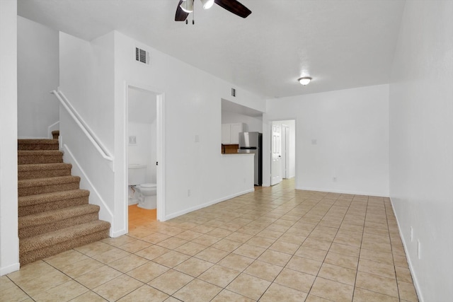 6933 Liverpool St, Houston, TX 77021 - unfurnished living room featuring a ceiling fan, stairway, light tile patterned flooring, and baseboards