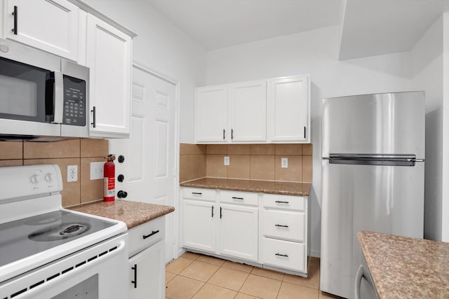 6933 Liverpool St, Houston, TX 77021 - kitchen with stainless steel appliances, backsplash, white cabinetry, and light tile patterned floors