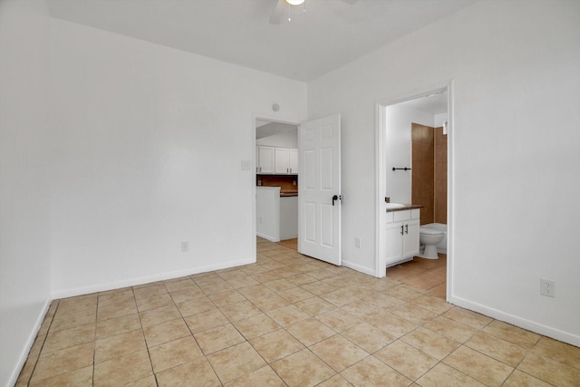 6933 Liverpool St, Houston, TX 77021 - unfurnished bedroom with light tile patterned flooring, baseboards, connected bathroom, and a ceiling fan
