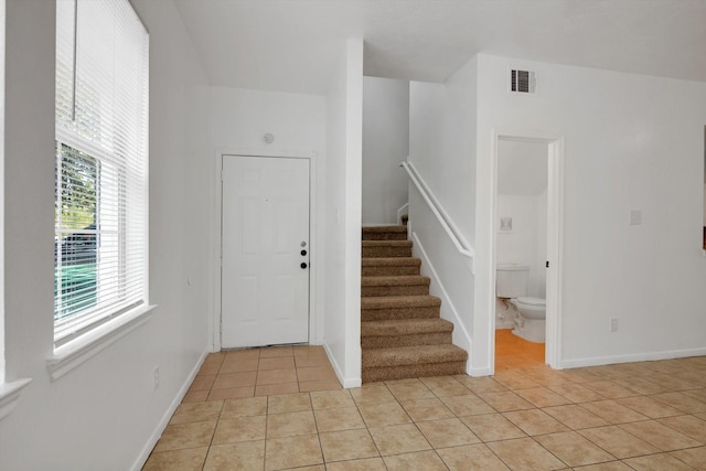 6933 Liverpool St, Houston, TX 77021 - entryway featuring light tile patterned flooring, stairs, and baseboards
