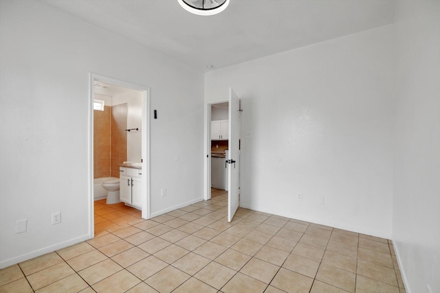 6933 Liverpool St, Houston, TX 77021 - unfurnished bedroom with light tile patterned flooring, connected bathroom, and baseboards