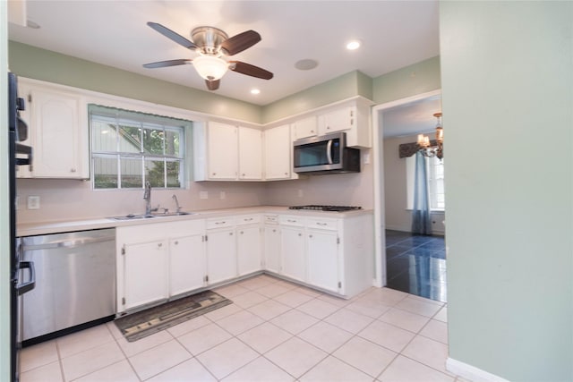 1918 Thousand Pines Dr, Houston, TX 77339 - kitchen with stainless steel appliances, light tile patterned floors, light countertops, white cabinets, and healthy amount of natural light