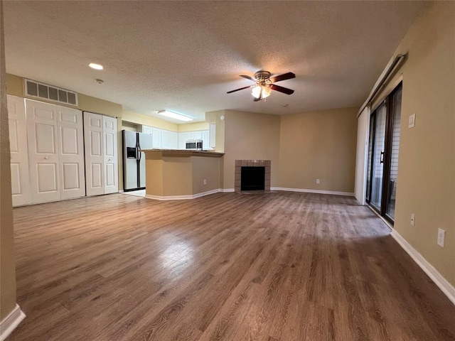 2300 Old Spanish Trl Unit 1111, Houston, TX 77054 - unfurnished living room featuring a textured ceiling, wood finished floors, ceiling fan, baseboards, and a fireplace