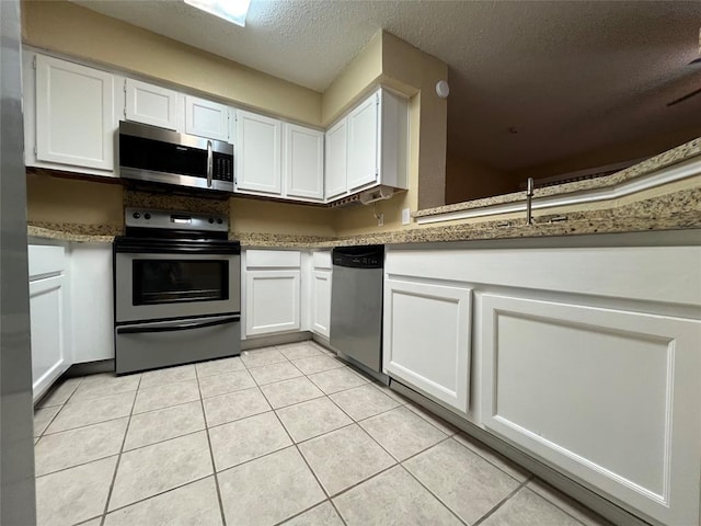 2300 Old Spanish Trl Unit 1111, Houston, TX 77054 - kitchen with stainless steel appliances, white cabinets, a textured ceiling, and light tile patterned floors