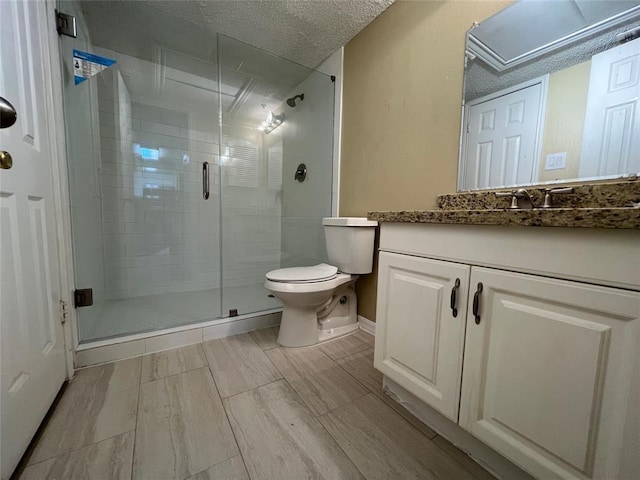 2300 Old Spanish Trl Unit 1111, Houston, TX 77054 - bathroom featuring toilet, a stall shower, wood finished floors, vanity, and a textured ceiling