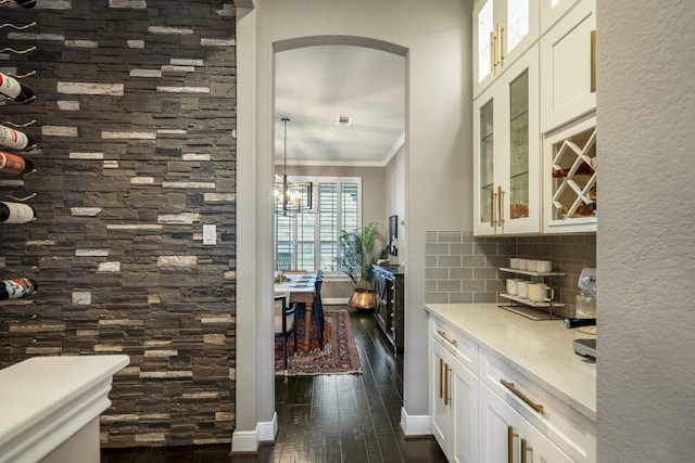 28203 Middlewater View Ln, Katy, TX 77494 - kitchen with arched walkways, dark wood finished floors, ornamental molding, tasteful backsplash, and white cabinets