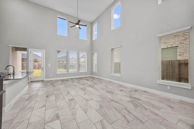 13207 Terania Cliff Trce, Houston, TX 77059 - unfurnished living room featuring a ceiling fan, a high ceiling, and baseboards