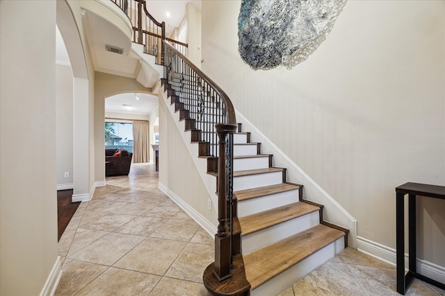 4436 Holt St, Bellaire, TX 77401 - stairway with arched walkways, a towering ceiling, and baseboards