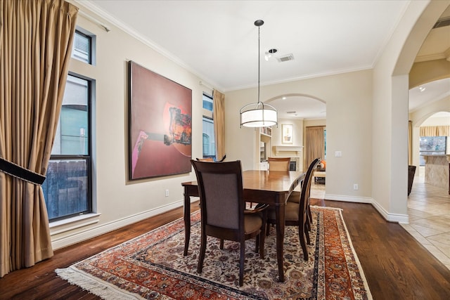 4436 Holt St, Bellaire, TX 77401 - dining space with arched walkways, wood finished floors, ornamental molding, and baseboards