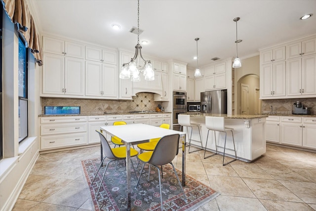 4436 Holt St, Bellaire, TX 77401 - kitchen with stainless steel appliances, backsplash, arched walkways, light stone counters, and a breakfast bar