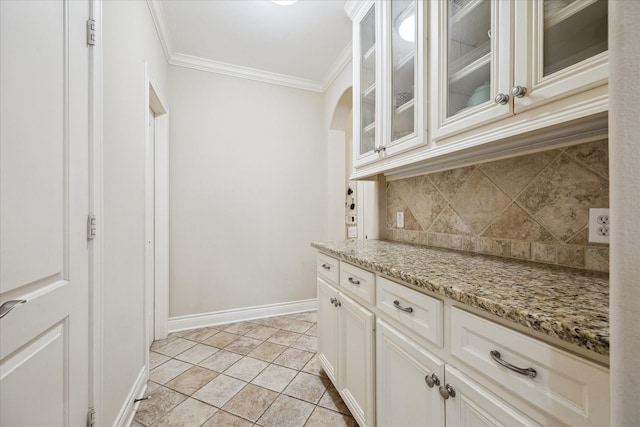 4436 Holt St, Bellaire, TX 77401 - kitchen featuring decorative backsplash, ornamental molding, baseboards, glass insert cabinets, and light stone countertops