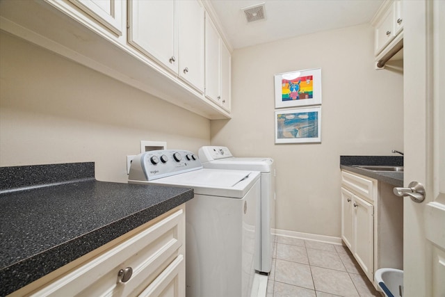 4436 Holt St, Bellaire, TX 77401 - laundry area with washer and dryer, light tile patterned floors, cabinet space, and baseboards