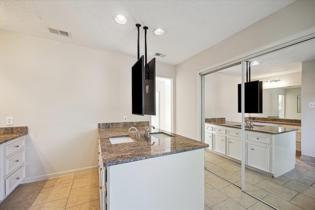 2302 Bright Meadows Dr, Missouri City, TX 77489 - bathroom with two vanities, recessed lighting, a textured ceiling, tile patterned floors, and baseboards