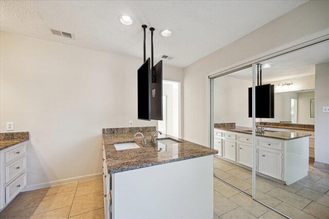 2302 Bright Meadows Dr, Missouri City, TX 77489 - bathroom with two vanities, recessed lighting, a textured ceiling, tile patterned floors, and baseboards