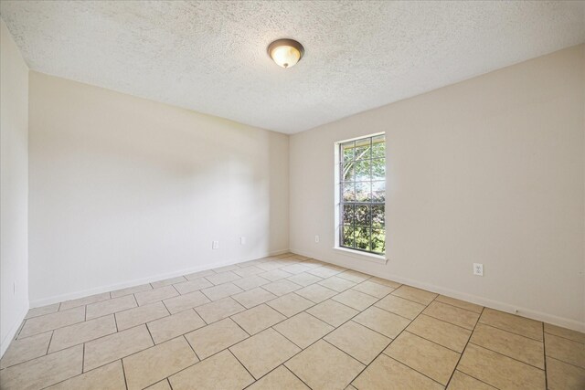 2302 Bright Meadows Dr, Missouri City, TX 77489 - spare room featuring a textured ceiling, light tile patterned flooring, and baseboards