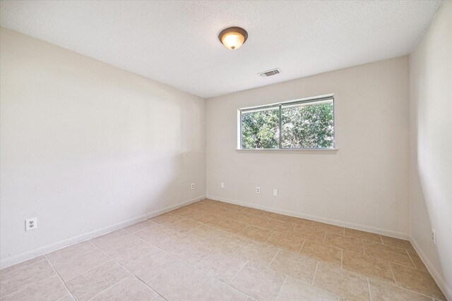 2302 Bright Meadows Dr, Missouri City, TX 77489 - unfurnished room with light tile patterned flooring, baseboards, and a textured ceiling