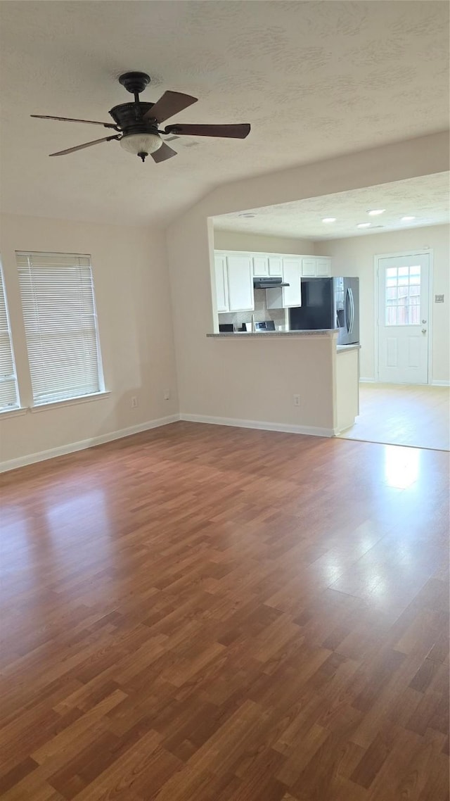 13418 Croquet Ln, Houston, TX 77085 - unfurnished living room with wood finished floors, a ceiling fan, lofted ceiling, and baseboards