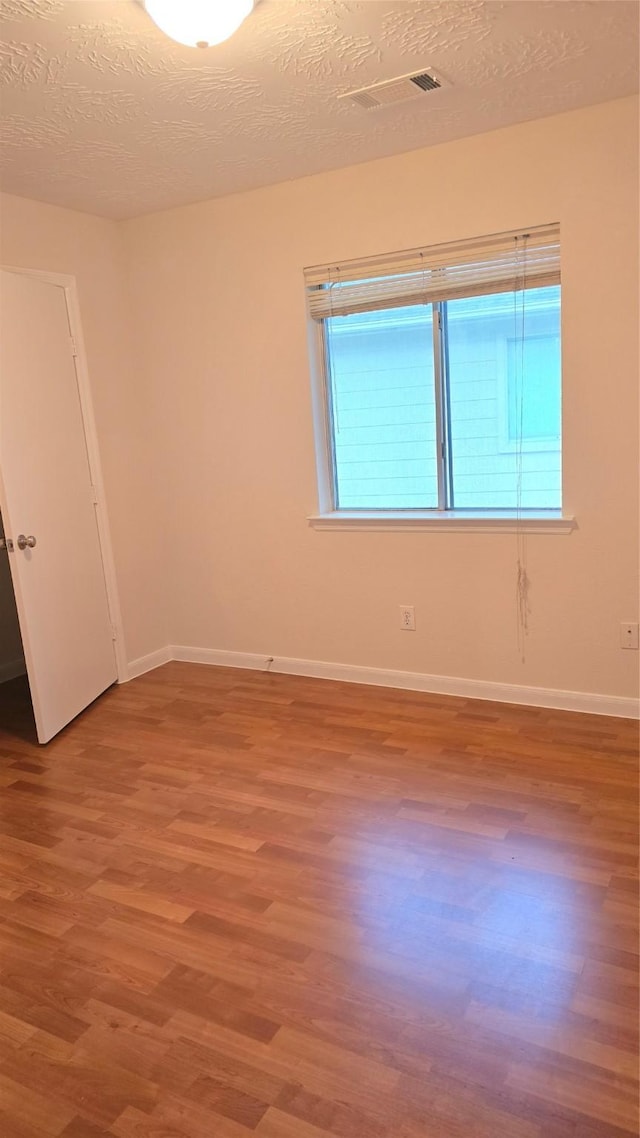 13418 Croquet Ln, Houston, TX 77085 - spare room featuring wood finished floors, baseboards, and a textured ceiling