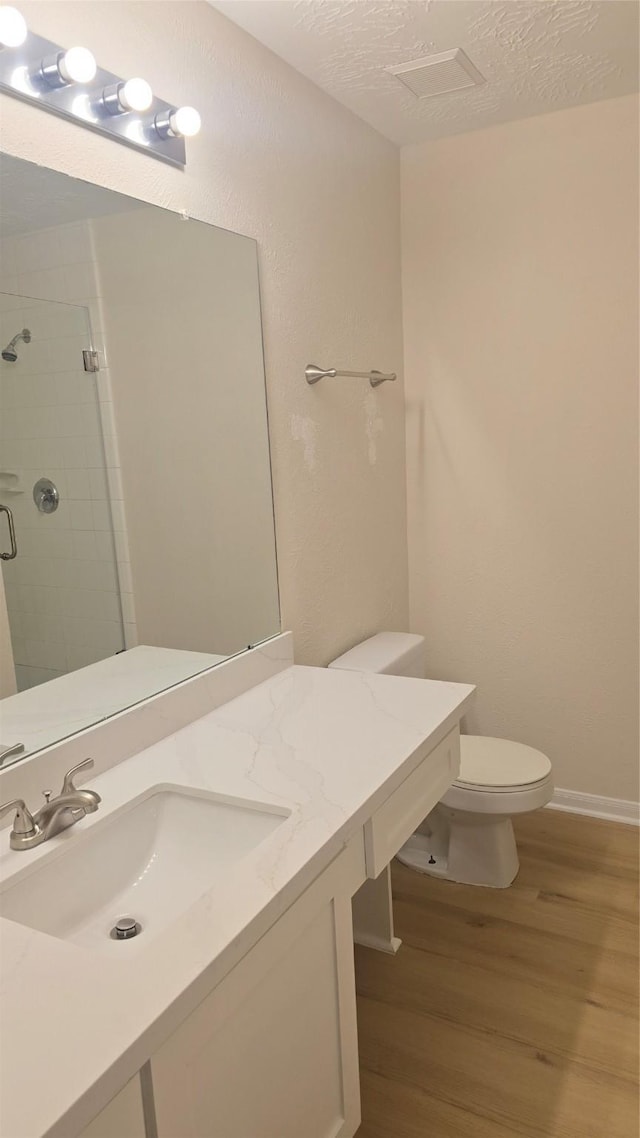 13418 Croquet Ln, Houston, TX 77085 - full bath with wood finished floors, a shower stall, toilet, vanity, and baseboards