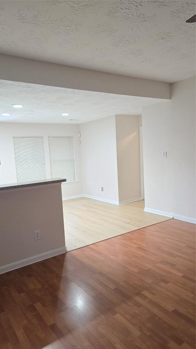 13418 Croquet Ln, Houston, TX 77085 - empty room with light wood-style flooring, baseboards, and a textured ceiling