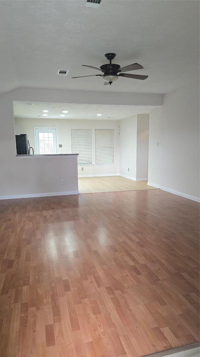13418 Croquet Ln, Houston, TX 77085 - unfurnished living room with a ceiling fan, light wood finished floors, and baseboards