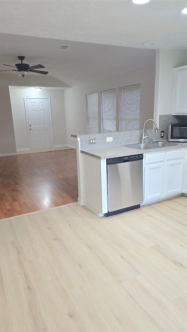 13418 Croquet Ln, Houston, TX 77085 - kitchen featuring appliances with stainless steel finishes, light wood finished floors, open floor plan, baseboards, and white cabinets