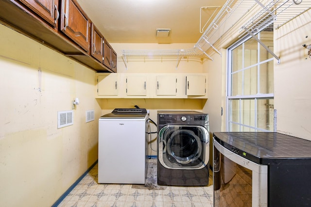 23423 Earlmist Dr, Spring, TX 77373 - laundry room featuring washing machine and dryer, cabinet space, light floors, and baseboards