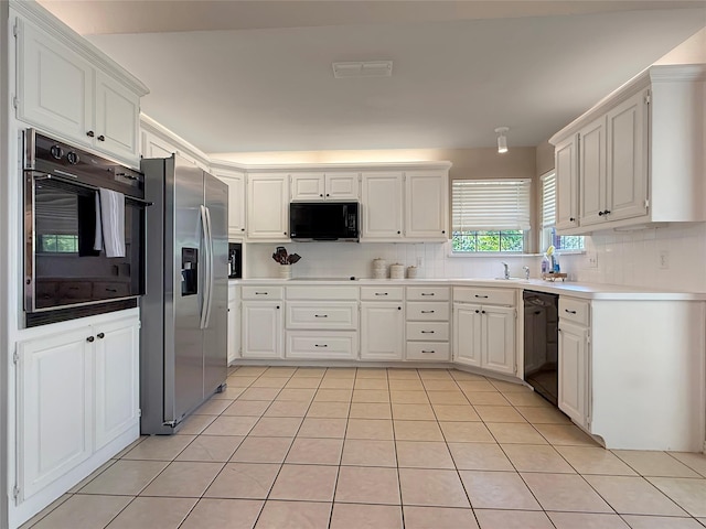 261 Colonial Cir, Athens, TX 75751 - kitchen with black appliances, backsplash, light tile patterned floors, and white cabinetry