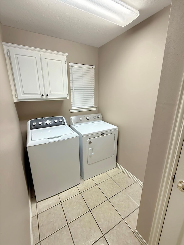 261 Colonial Cir, Athens, TX 75751 - laundry area featuring independent washer and dryer, cabinet space, light tile patterned floors, and baseboards
