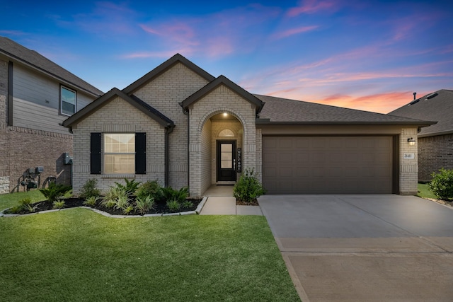 21411 Waldenburg Pl, Tomball, TX 77375 - french country style house featuring brick siding, a garage, concrete driveway, and a front lawn