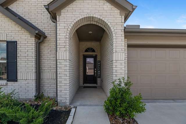 21411 Waldenburg Pl, Tomball, TX 77375 - doorway to property featuring an attached garage, brick siding, and driveway