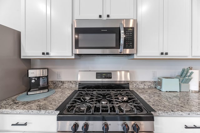 21411 Waldenburg Pl, Tomball, TX 77375 - kitchen featuring stainless steel appliances, white cabinetry, and light stone counters
