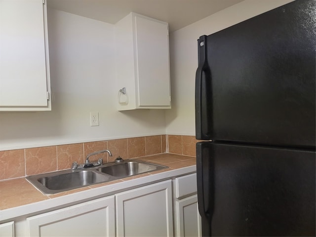 5806 Bayou Bend Ct, Houston, TX 77004 - kitchen featuring freestanding refrigerator, a sink, and white cabinets