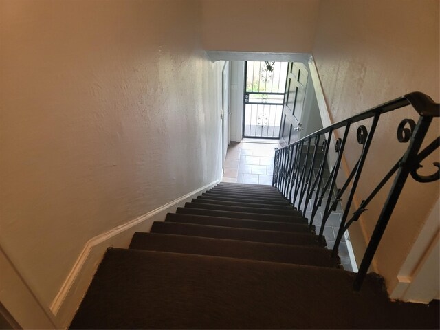 5806 Bayou Bend Ct, Houston, TX 77004 - stairs featuring a textured wall, carpet, and baseboards