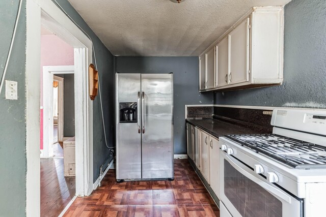 2005 Chestnut St, Houston, TX 77009 - kitchen featuring stainless steel fridge, gas range gas stove, a textured ceiling, dark countertops, and dark wood-style floors
