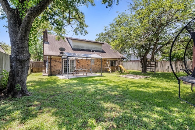 19414 Gooselake Ln, Houston, TX 77084 - rear view of property with a playground, brick siding, a trampoline, a patio area, and a chimney