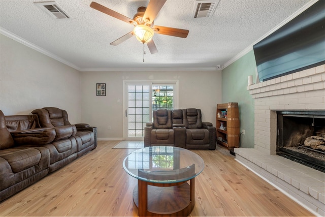 19414 Gooselake Ln, Houston, TX 77084 - living area with wood finished floors, a ceiling fan, a textured ceiling, ornamental molding, and a brick fireplace