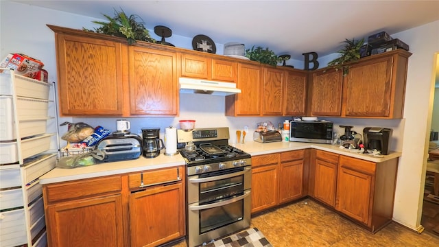 19622 Sasquatch Dr, Tomball, TX 77377 - kitchen with range with two ovens, under cabinet range hood, light countertops, and brown cabinetry