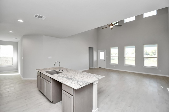 12027 Maple Oak Dr, Houston, TX 77066 - kitchen featuring a sink, ceiling fan, baseboards, open floor plan, and light wood finished floors