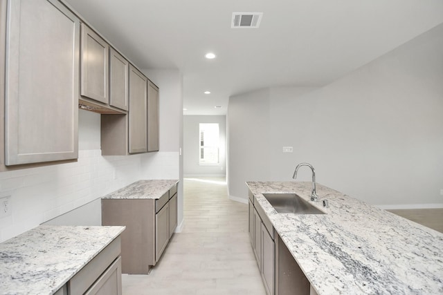 12027 Maple Oak Dr, Houston, TX 77066 - kitchen with a sink, light stone counters, backsplash, baseboards, and recessed lighting