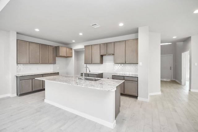 12027 Maple Oak Dr, Houston, TX 77066 - kitchen featuring a sink, backsplash, a kitchen island with sink, recessed lighting, and light wood finished floors