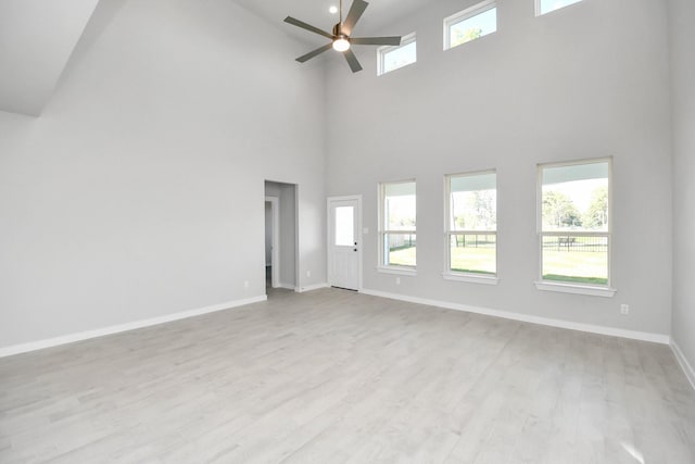 12027 Maple Oak Dr, Houston, TX 77066 - unfurnished room featuring a ceiling fan, a towering ceiling, baseboards, and light wood-style floors