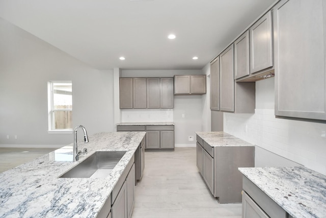 12027 Maple Oak Dr, Houston, TX 77066 - kitchen featuring a sink, light stone counters, recessed lighting, tasteful backsplash, and light wood-style flooring