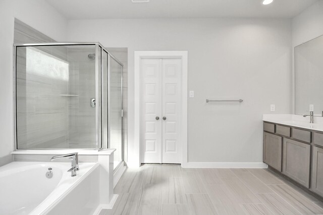 12027 Maple Oak Dr, Houston, TX 77066 - bathroom with a stall shower, a garden tub, vanity, baseboards, and recessed lighting