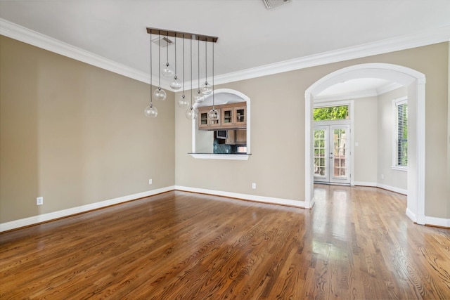 1335 Fairview Ave, Houston, TX 77006 - empty room featuring arched walkways, crown molding, wood finished floors, and baseboards